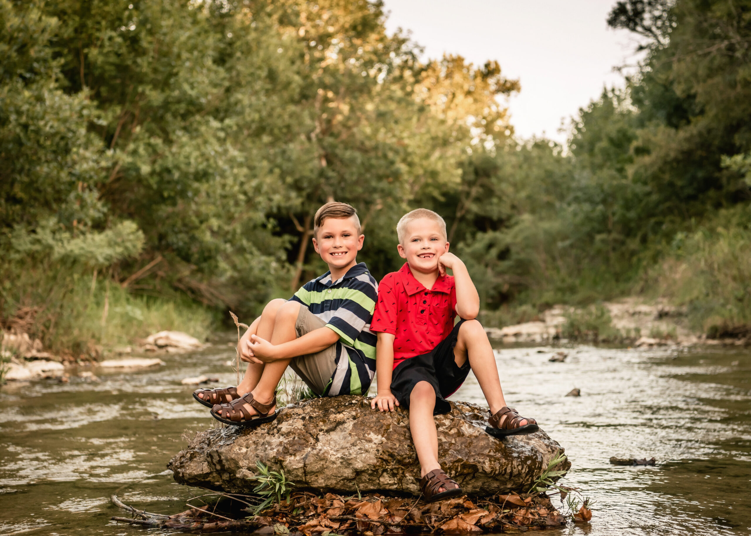 brothers sitting on a rock in the river