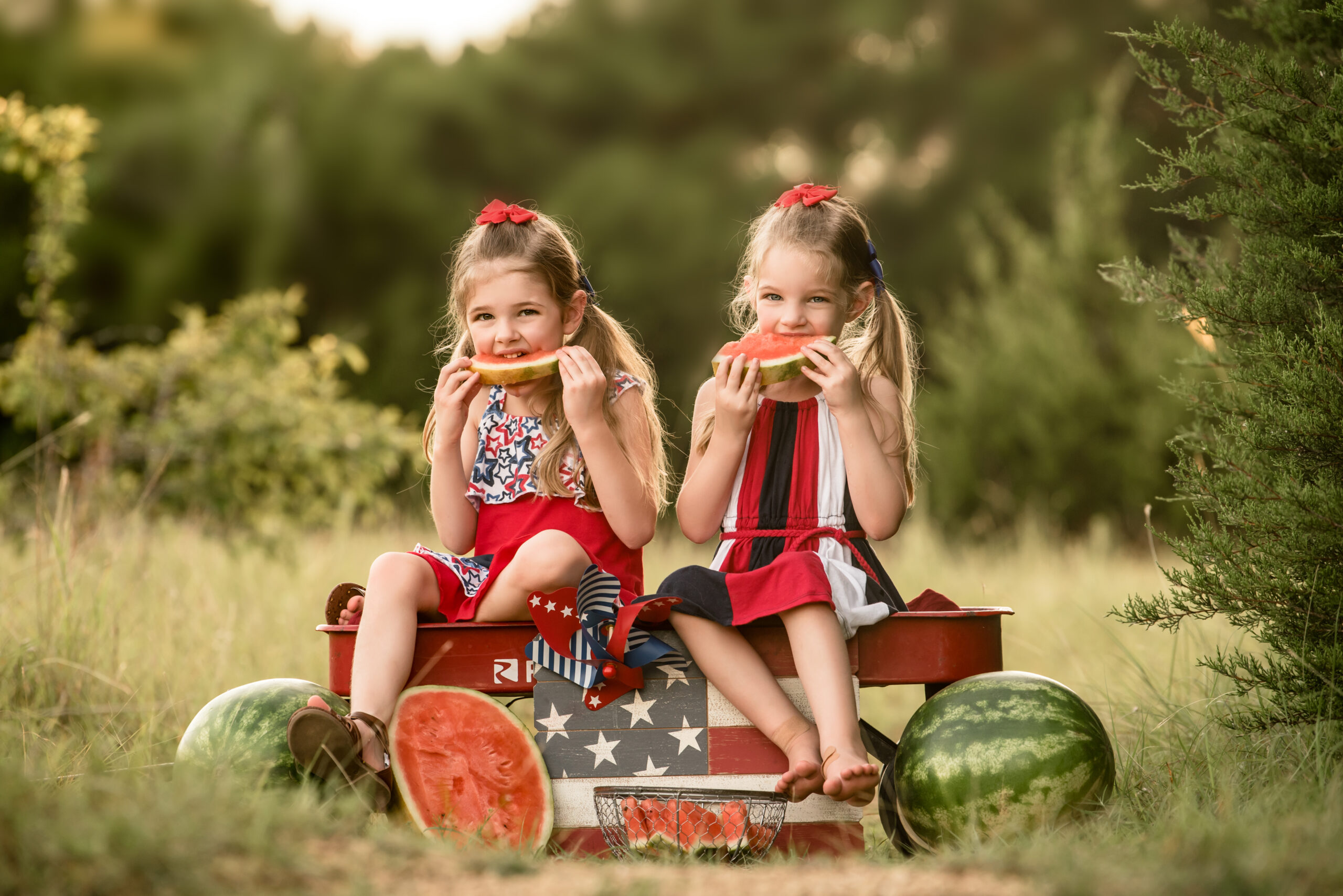 little girls sitting in a red wagon eating watermelon Things To Do in Waco with Kids