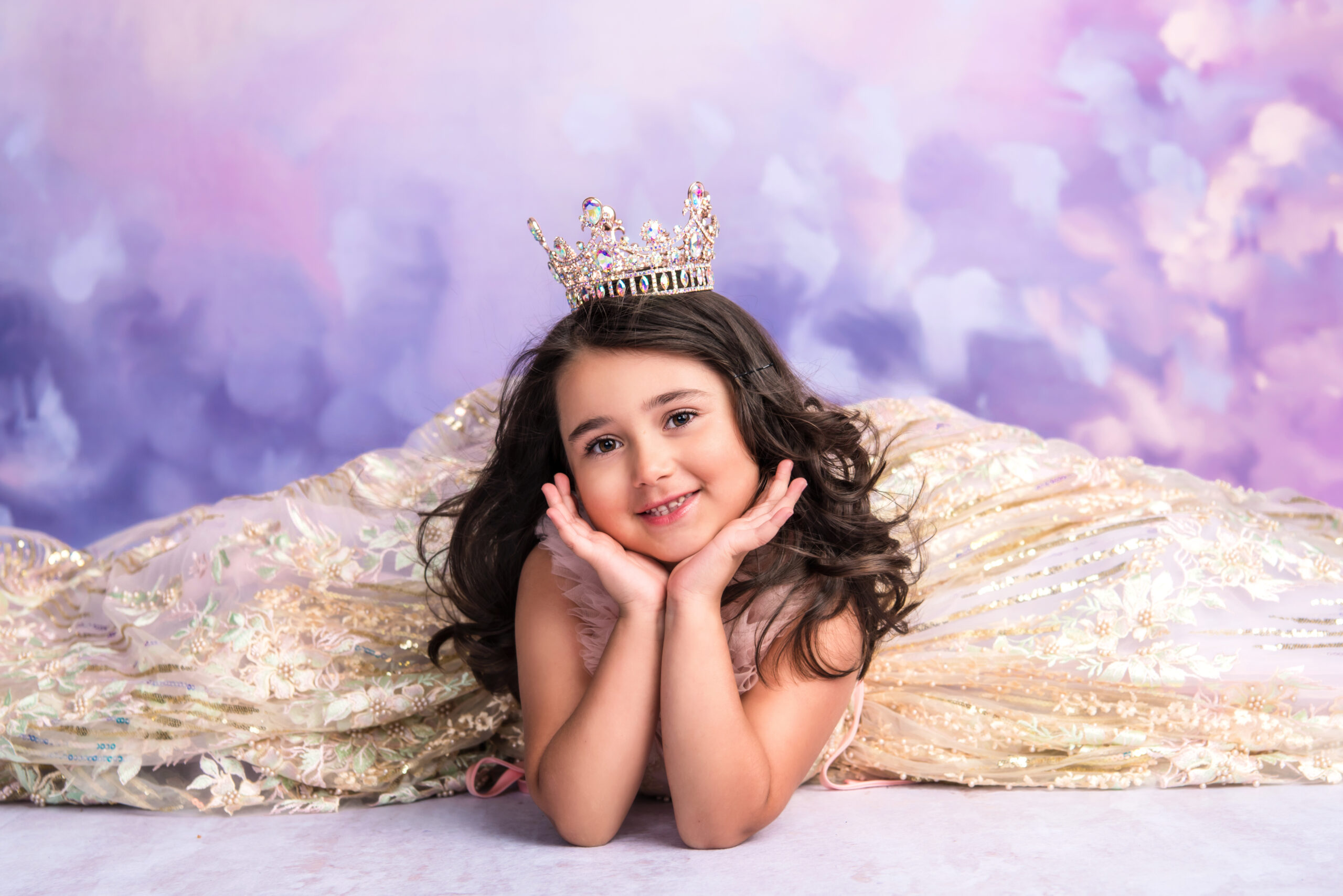 young girl in gold dress and tiara