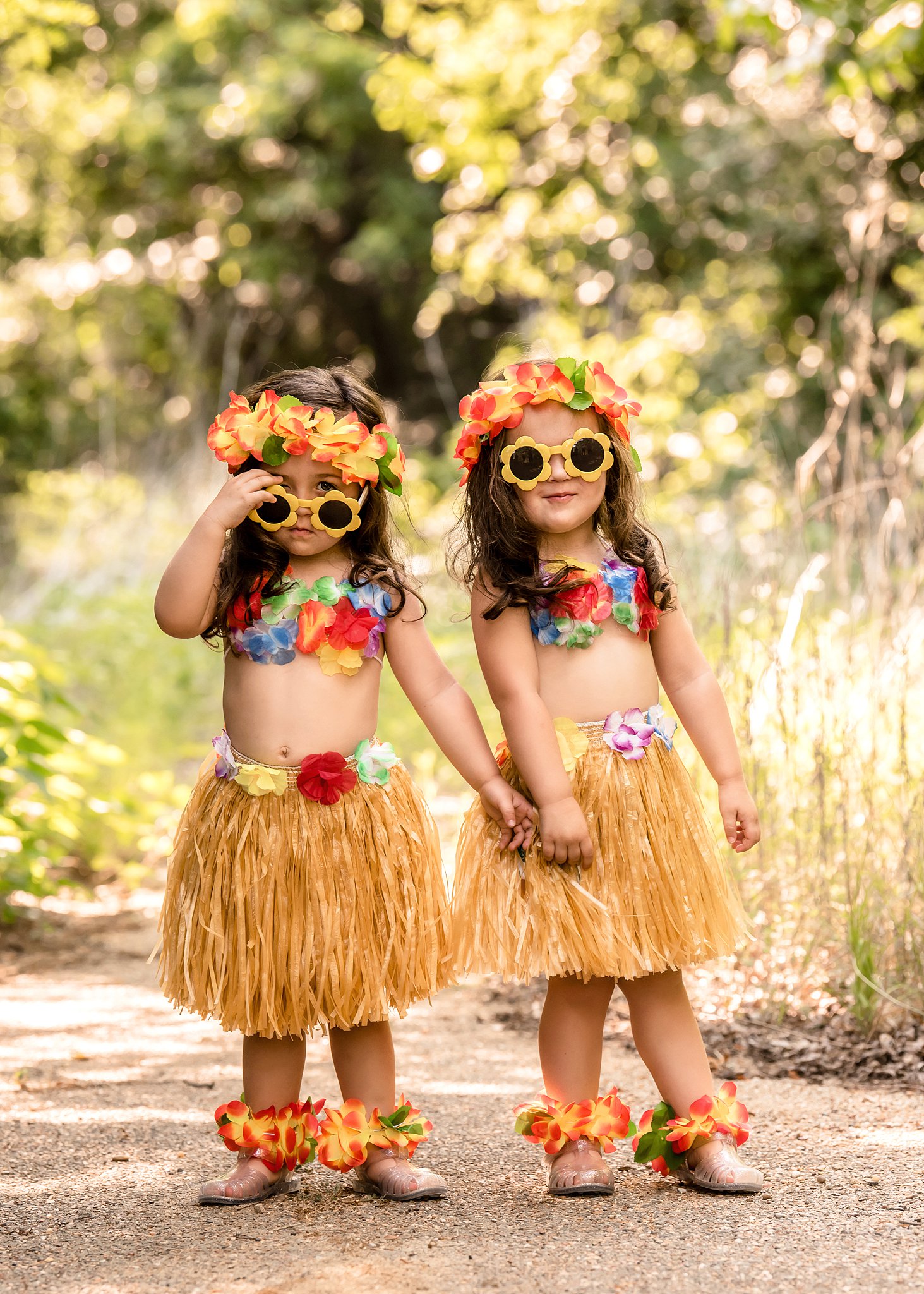 twins dressed for a Hawaiian luau stand holding hands in a park path Rock and Roll Ice Cream Parlor
