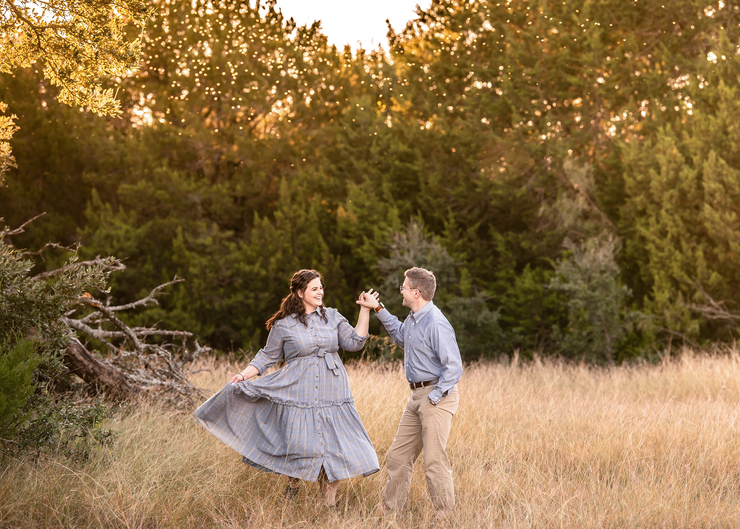 A happy couple dances in a park field at sunset during one of the date ideas in waco